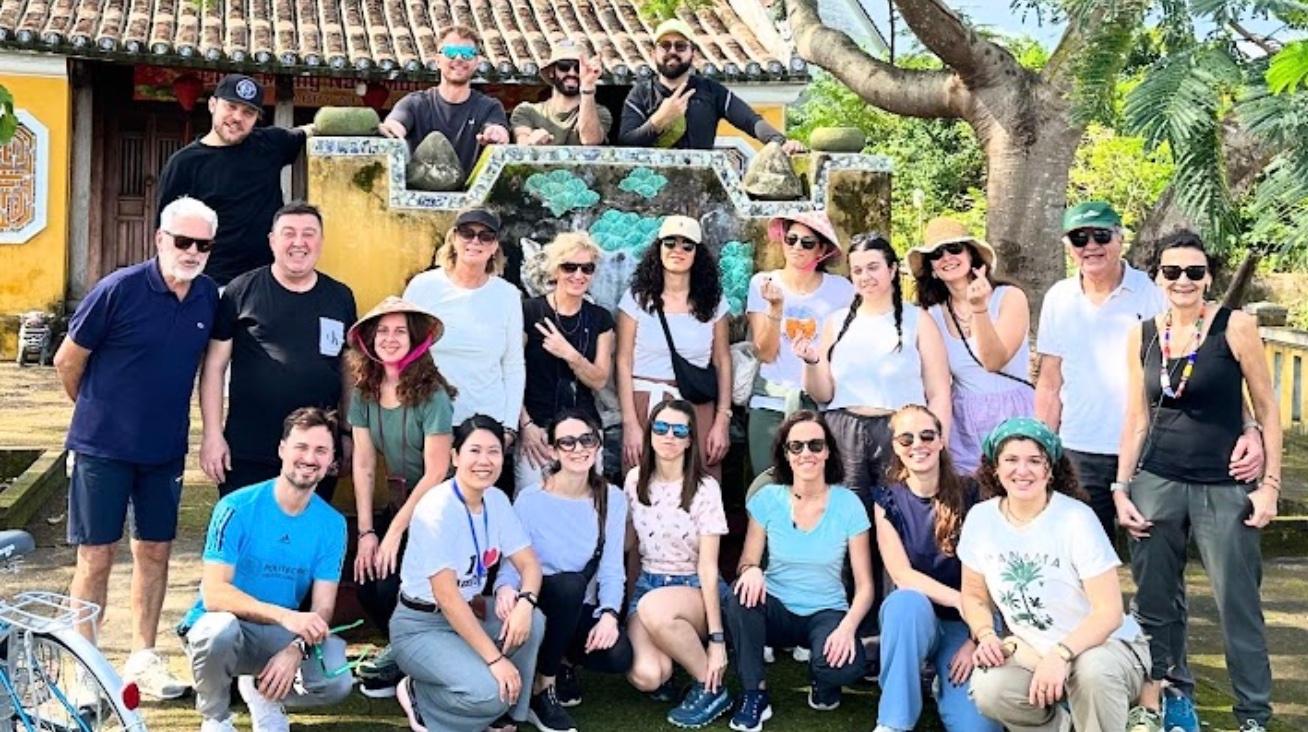 Group of travellers posing in front of a yellow house in the old town
